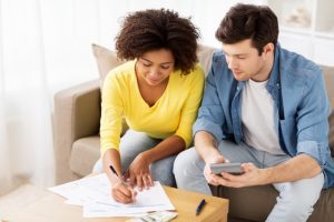 Couple sitting on couch doing paper work together